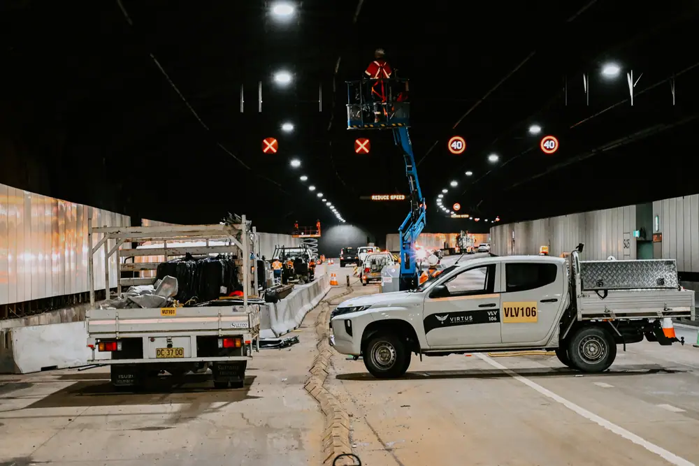 A Virtus Infrastructure ute and an elevated work platform inside a closed motorway tunnel during night works.