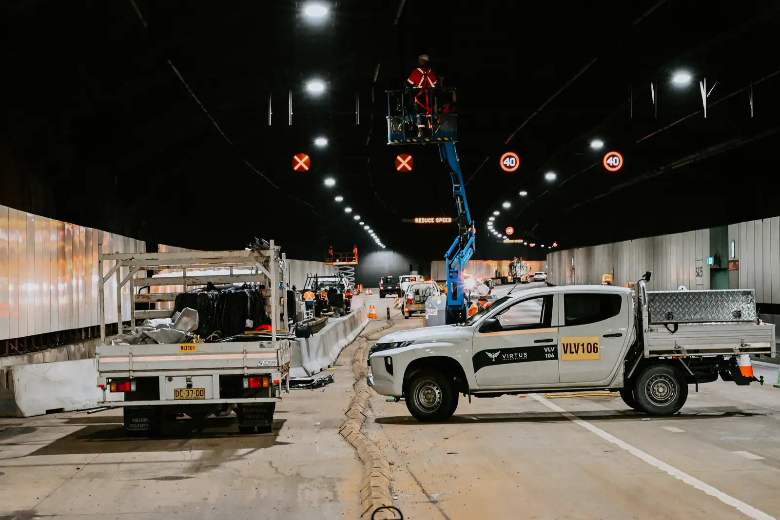 A Virtus Infrastructure ute and an elevated work platform inside a closed motorway tunnel during night works.
