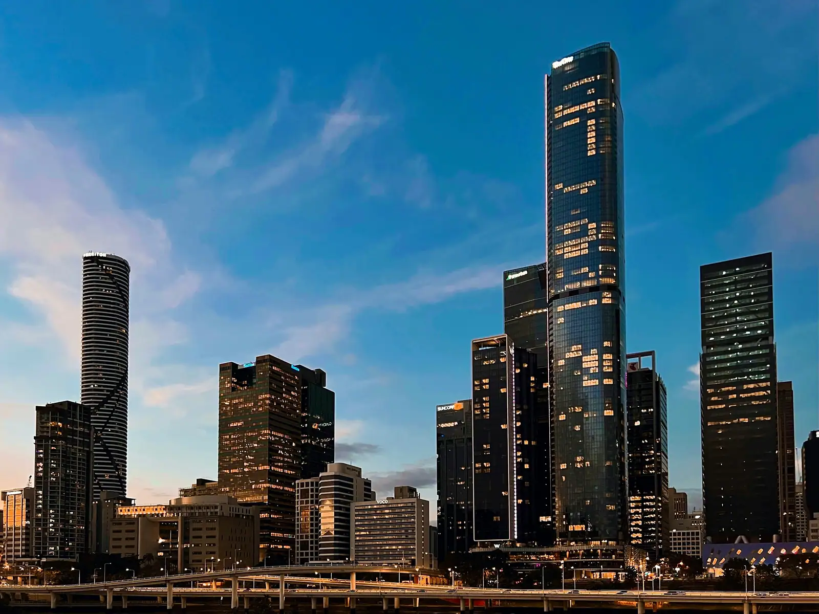 The Melbourne skyline at dusk, its towers rendered in the blue two-tone dither against a natural sky.